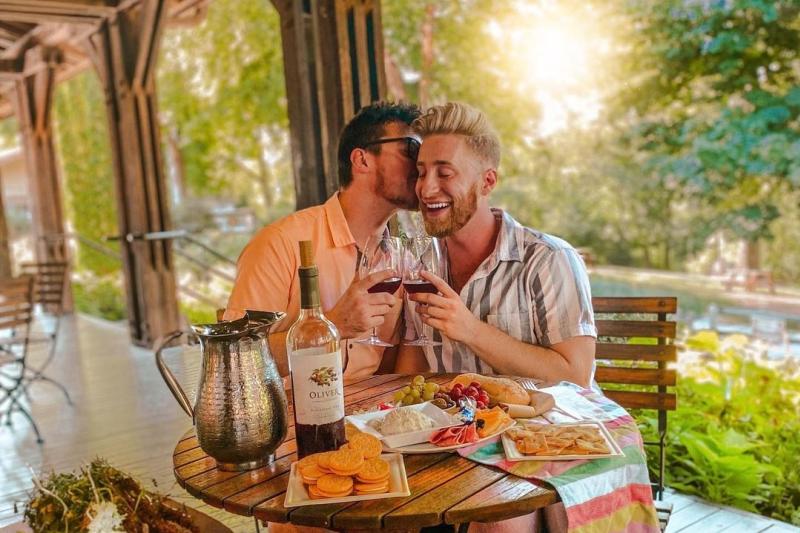 A couple enjoying a wine tasting and charcuterie board at Oliver Winery
