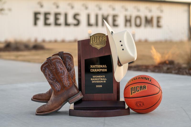 NJCAA Trophy decorated with boots, a cowboy hat, and the game ball outside of the Brownwood Event Center