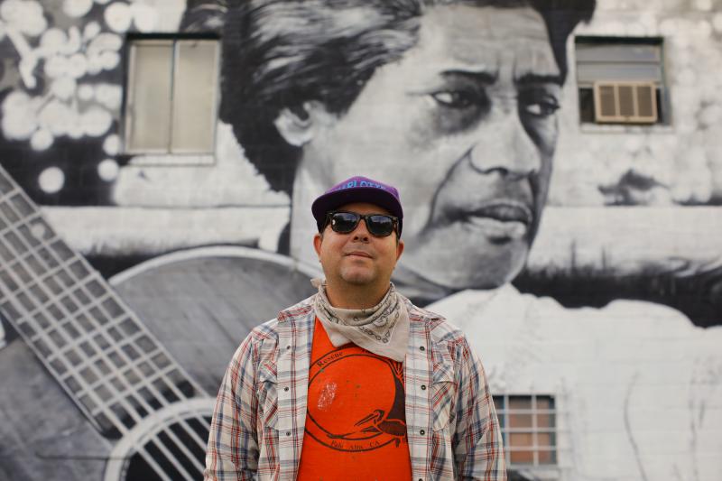 Artist Scott Nurkin in front of his mural, Elizabeth Cotten in Carrboro