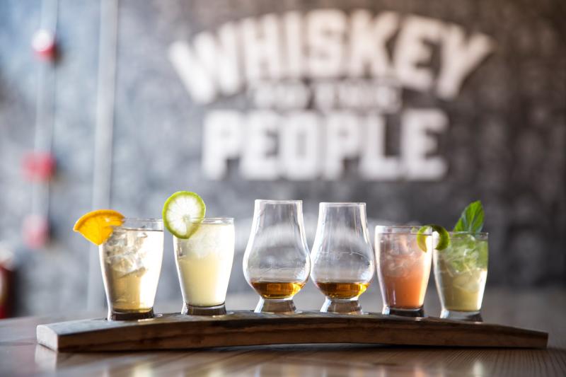 flight of Chattanooga Whiskey drinks in front of sign that reads Whiskey to the People