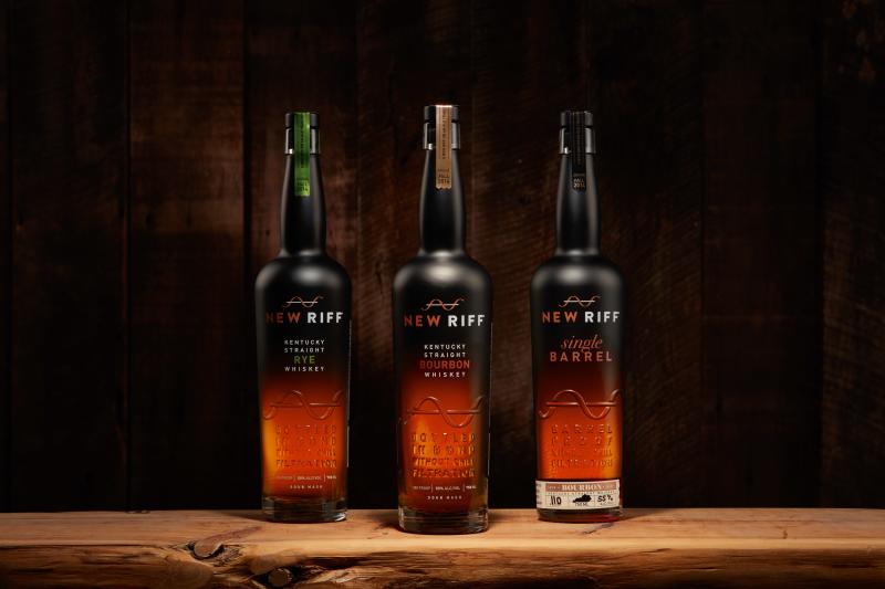 Three bottles of New Riff bourbon sit on a wooden table.
