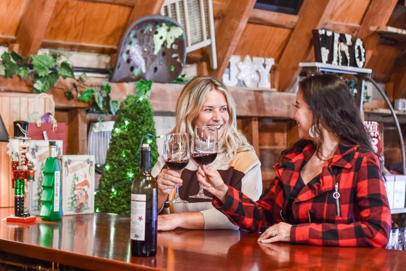 Women cheers wine glasses at Huber's during the holidays