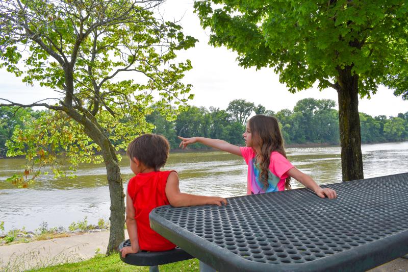 kids at a picnic table by a river