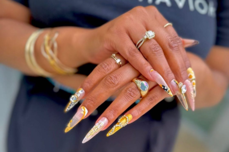 Woman's long nails decorated with jewels and nail art