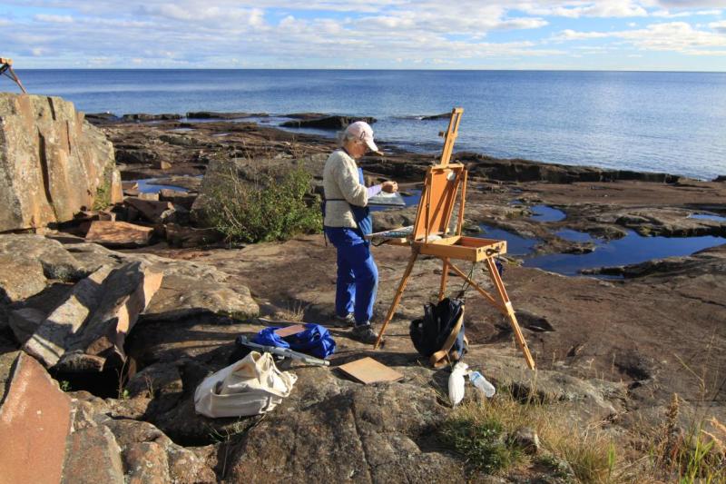 An individual painting on the shores of lake superior.