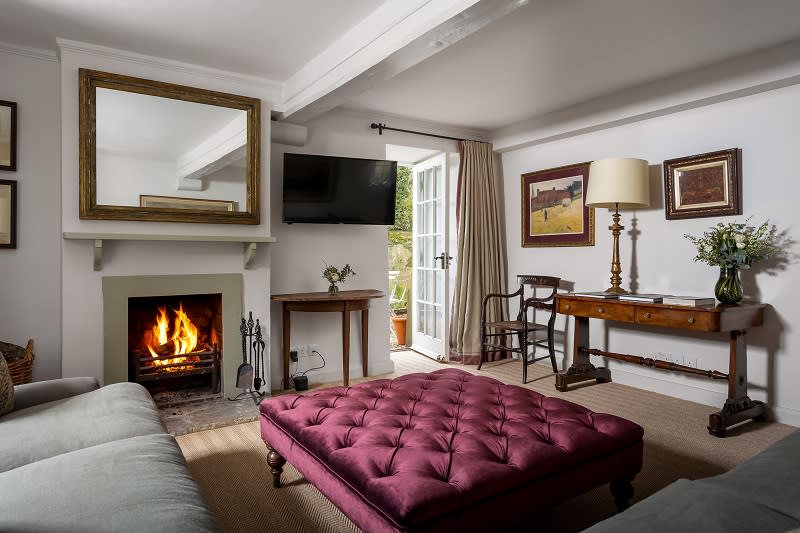 A roaring fire is the focal point of an elegant cottage living room