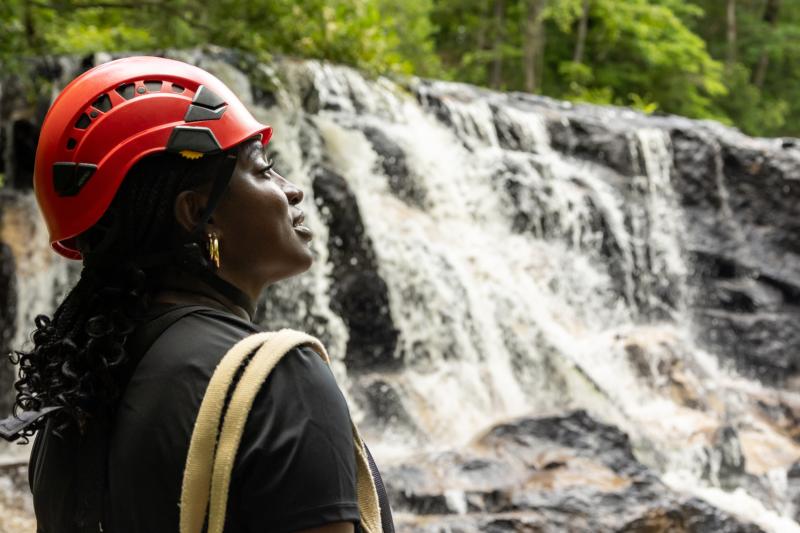 Image of an African American woman with a waterfall at ZipQuest