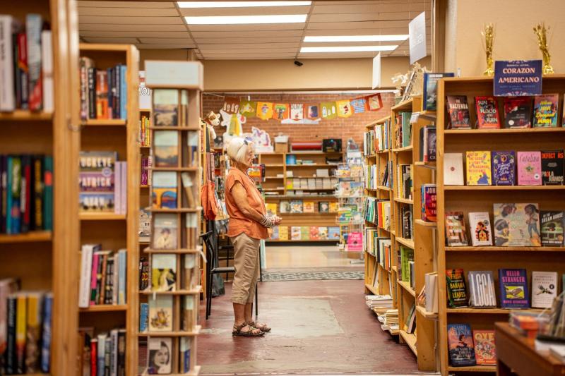 Lady looking at books in an aisle.