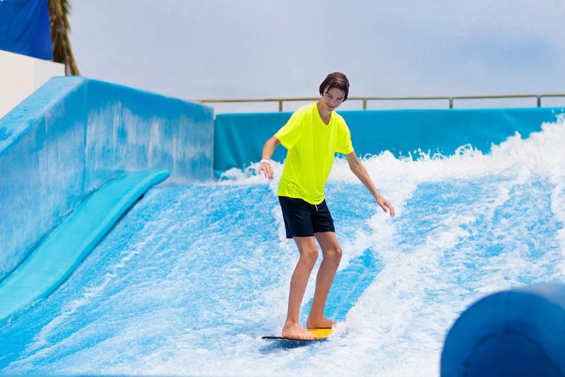 A person on a surf board using a wave machine