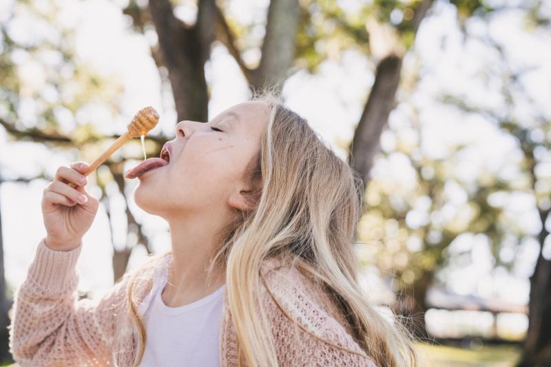 young girl tasting Tupelo Honey