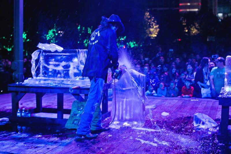 A man uses a chain saw to create an ice sculpture during Frostival at Discovery Green
