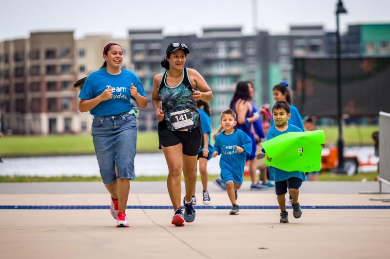 Two women and children running at the Irving Marathon
