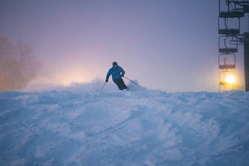Skier shredding fresh powder at Marquette Mountain
