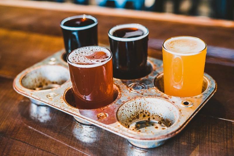 Four beers served in a six-cavity muffin tin at Blue Wolf Brewing