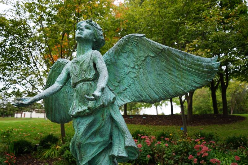 Statue of an angel with open arms at Maple Grove Arboretum