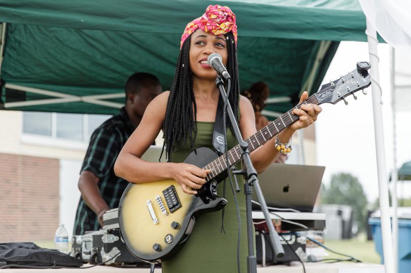 Women with a guitar performing at microphone