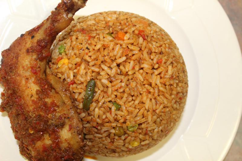 A white plate with a chicken leg and rice from Mama Ti's African Kitchen