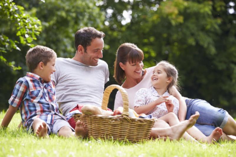family laughing while enjoying a picnic