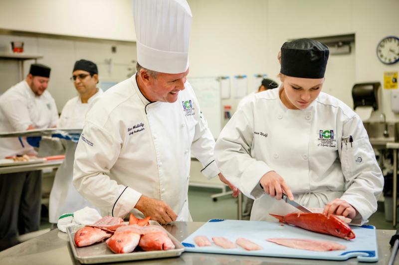 Cooking student cutting fish at ICI