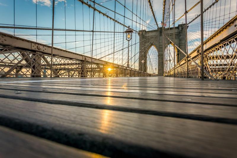 brooklyn bridge planks and suspension with the sun beginning to set