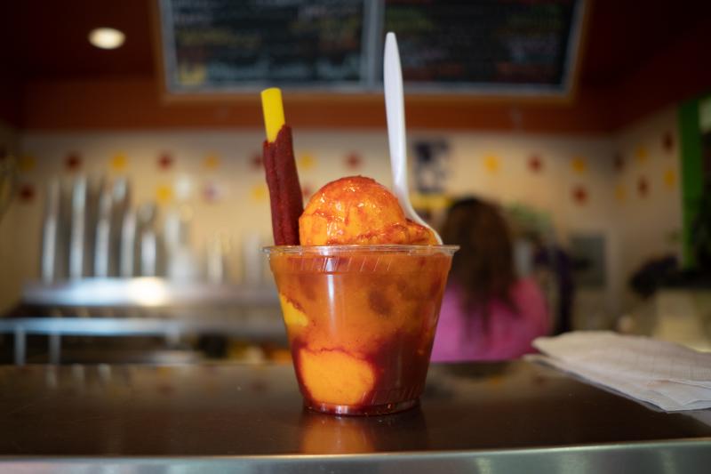 Nieves mangonada dessert in a cup on a metal countertop