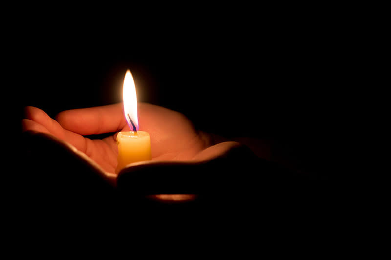 A candle in a person's hands