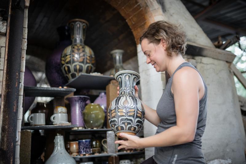 Seagrove Potter looking at a collection of Pottery