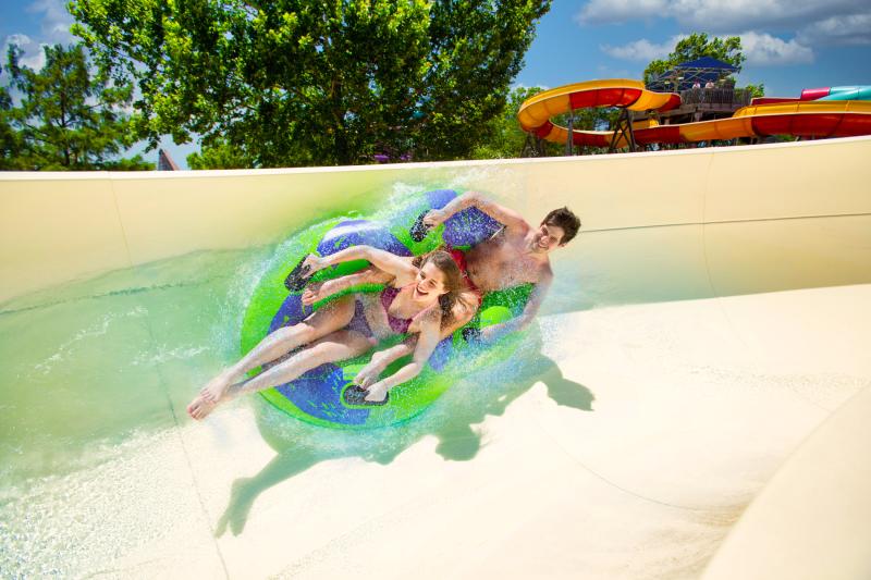 Two riders on a two-rider tube on a waterslide