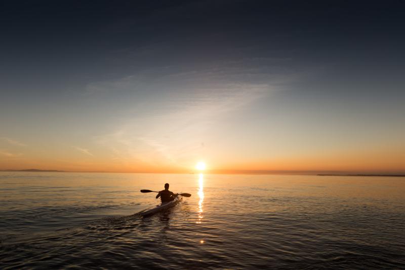 Man-kayaking-on-the-bay-during-the-sunset