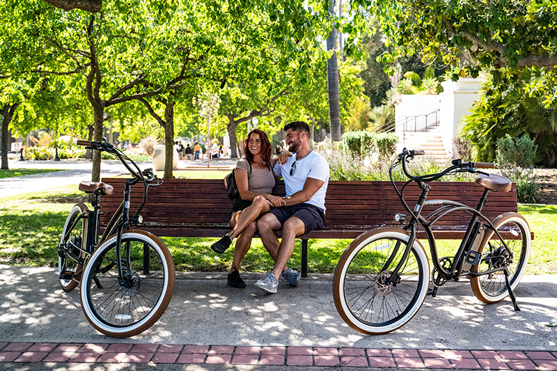 Two people sitting on bench in park