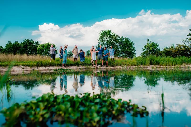 People outdoors by pond