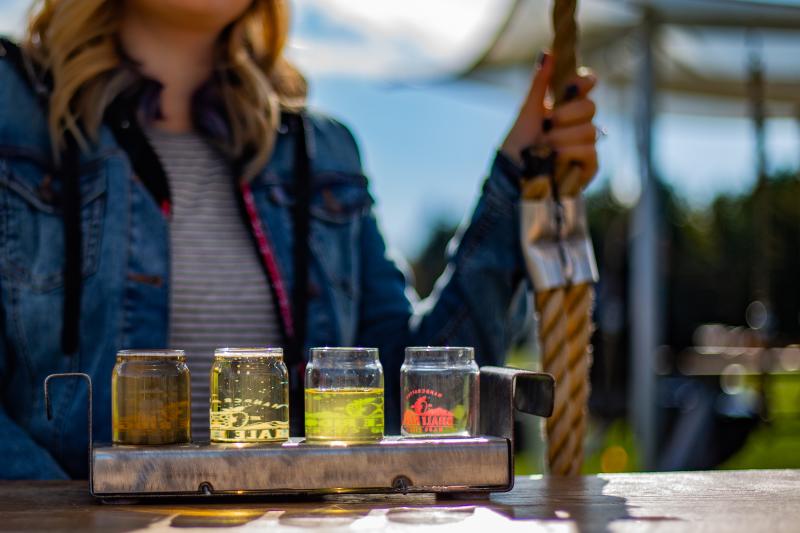 woman on picnic table with cider