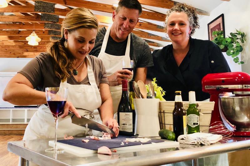 Friends drinking wine while taking a culinary cooking class