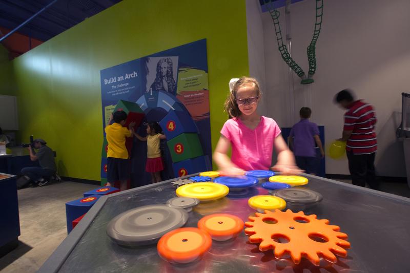 Girl playing at the "How Does it Work" area at the Fort Bend Children's Discovery Center