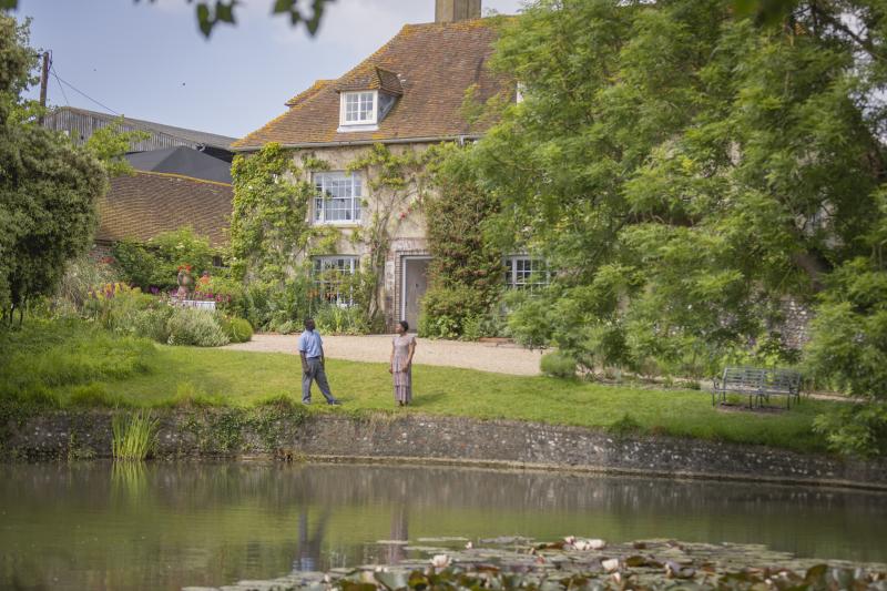 A couple stand by a pond outside Charleston farmhouse in Sussex