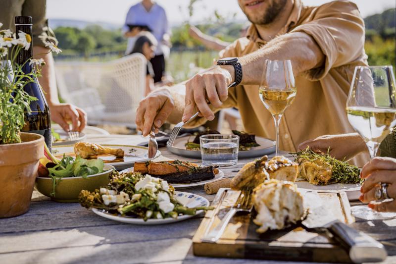 A group of people sharing plates of food at Artelium vineyard