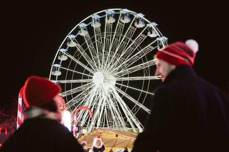 A couple standing in front of the Waterfront Winterland Big Wheel