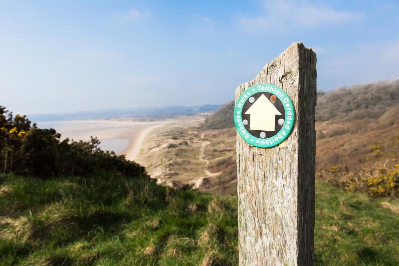 Walking sign post with Crawley beach in the background.