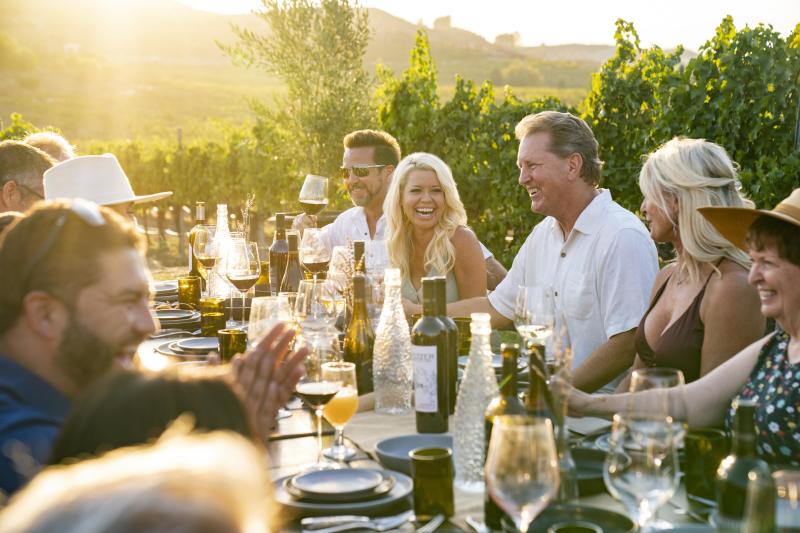 A group of friends enjoying a dinner at sunset, ourdoors
