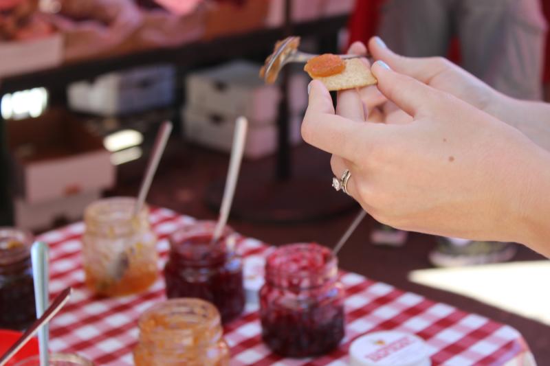 A person samples jams at the Vancouver Farmers Market