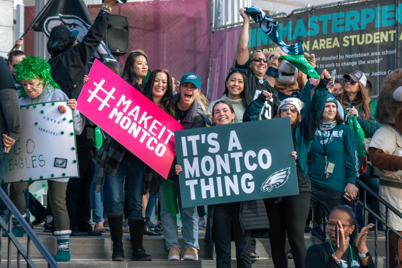 Fans holding Make It Montco and It's A Montco Thing signs at the Montgomery County Eagles Pep Rally