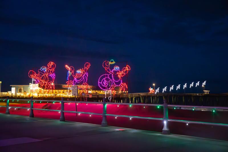 Holiday Lights at the Virginia Beach Oceanfront alongside the boardwalk railing with the Virginia Beach Fishing Pier in the Distance