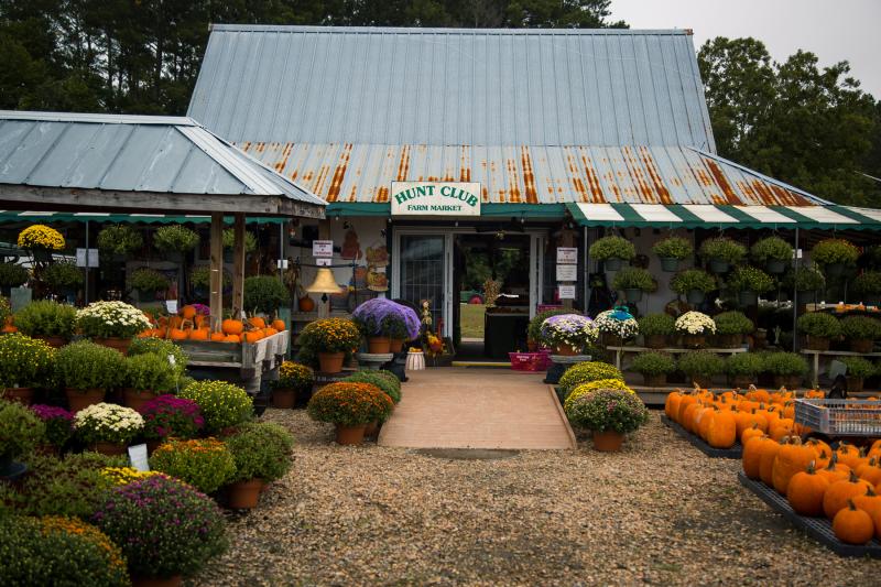 front of barn with pumpkins and farm goods