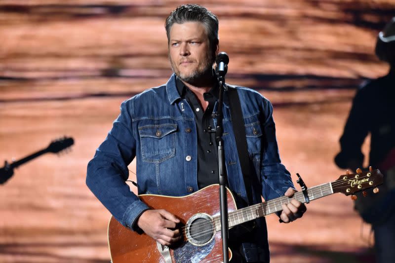 Country music star Blake Shelton performs on stage whlie playing a guitar