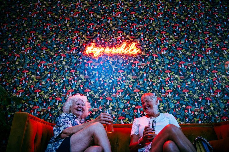 Two women smile while enjoying a beer at Hopping Gnome.