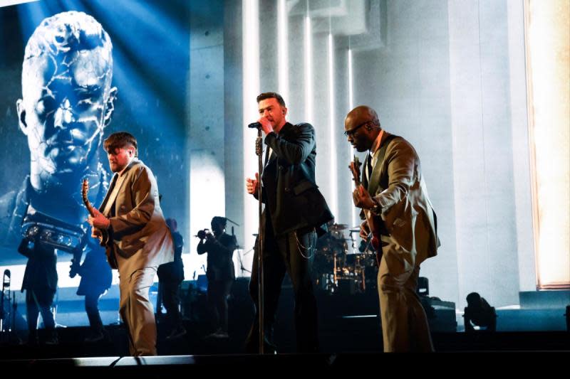 Justin Timberlake performs on stage with two guitarists
