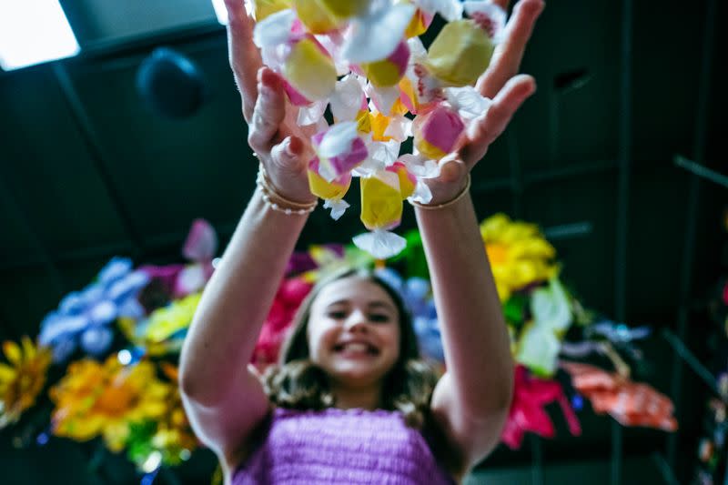 A girl drops a handful of candies and smiles at Nifty Nut House