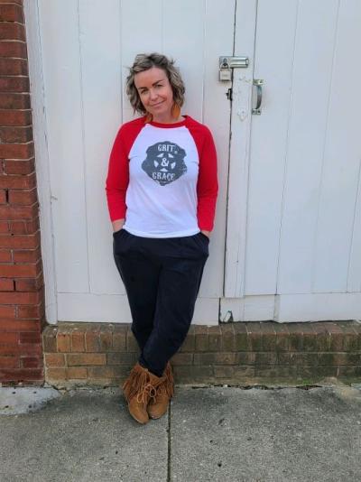 Woman with short hair and red sleeves on white shirt and jeans