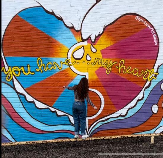 mural in shades of orange, pink, blue, red, and white forming waves in the shape of a heart. Inside the heart is "You have...my heart"