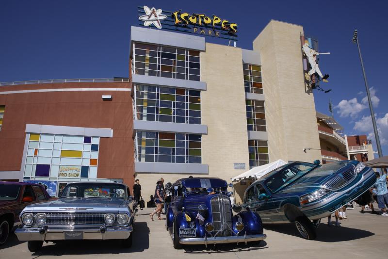 A shot of the exterior of Isotopes Park with lowriders lined up outside.